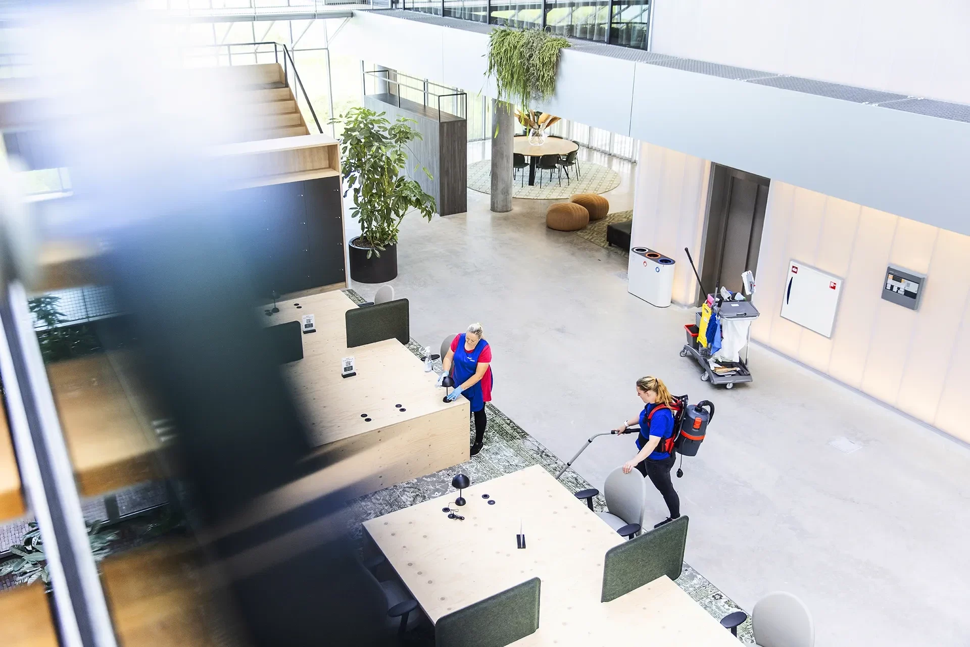 Twee schoonmakers van NFD in een kantooratrium